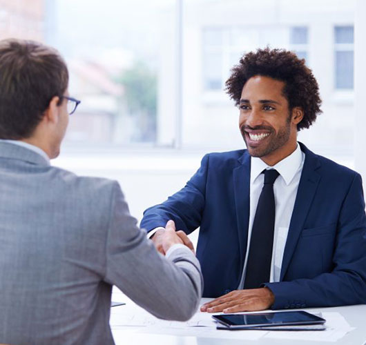 A man shaking hands with a potential employer during an interview